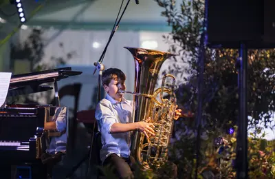 Ein Junge der auf einem der auf einer Tuba spielt.