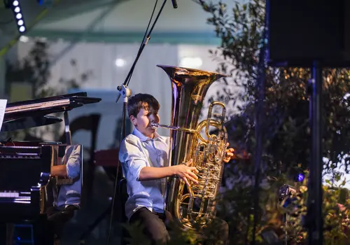 Ein Junge der auf einem der auf einer Tuba spielt.