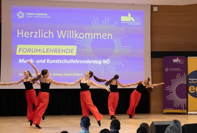Tanzende Personen bei einer Bühnenperformance vor dem Publikum.