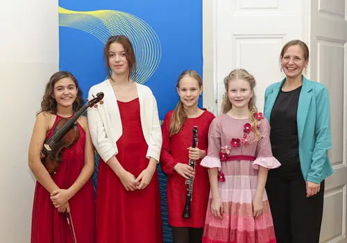 Gruppenfoto der vier Solistinnen und einer fünften Person.. Zwei halten ihre Instrumenten. 