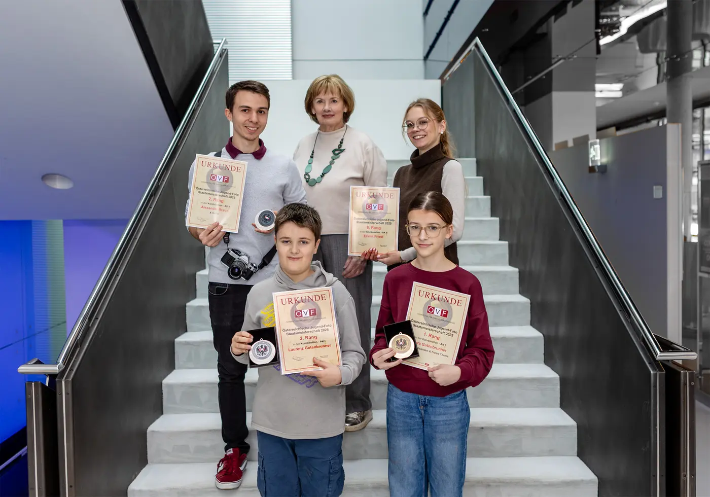 Vier Personen mit ihren Urkunden in der Hand. In der Mitte steht die Referentin der Akademie.