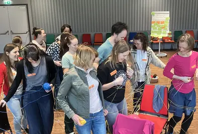 Teilnehmende versuchen gemeinsam die Wolle zu entwirren.