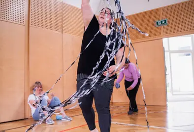 Eine Person wirbelt Wolle durch die Luft.