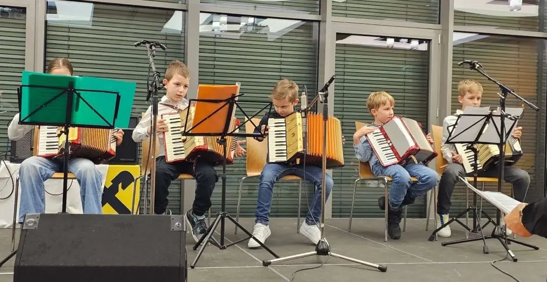 Kinder spielen auf ihrem Akkordeon.
