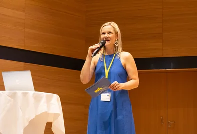 Tamara Ofenauer-Haas mit Mikrofon auf der Bühne.