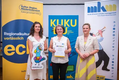 Teilnehmende Person und Vortragende posieren mit Zertifikat.