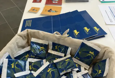 Tisch mit Flyern, Stickern und Gummibärchen mit dem mkm Branding darauf.