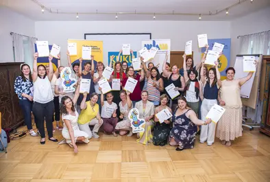 Energetisches Gruppenfoto der teilnehmenden Personen mit Zertifikaten.