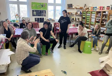 Teilnehmende hören dem Vortragenden zu während er etwas erklärt.