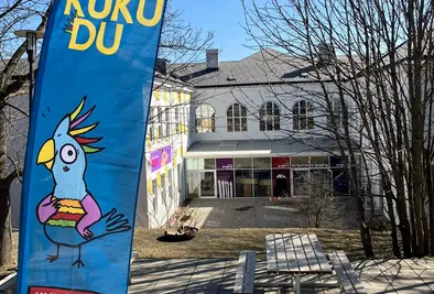 Gebäude von hinten und davor eine Beachflagge mit dem KUKUDU Logo