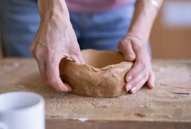 Nahaufnahme einer Person die eine Schüssel modelliert.