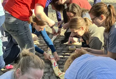 Teilnehmende basteln eine Schlange aus Klebestreifen.