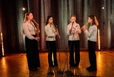 Vier Personen spielen gemeinsam Blockflöte auf einer Bühne.