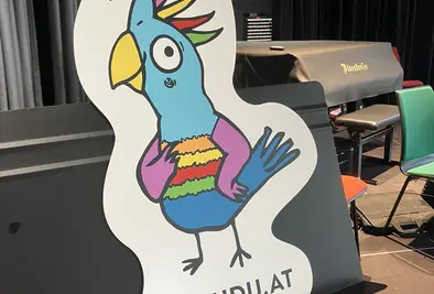 Das KUKUDU Logo in Papierform auf einem Notenständer.