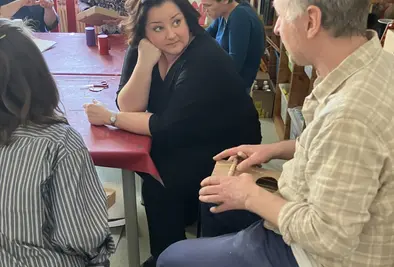 Eine Frau hört aufmerksam ihrem Gegenüber zu.