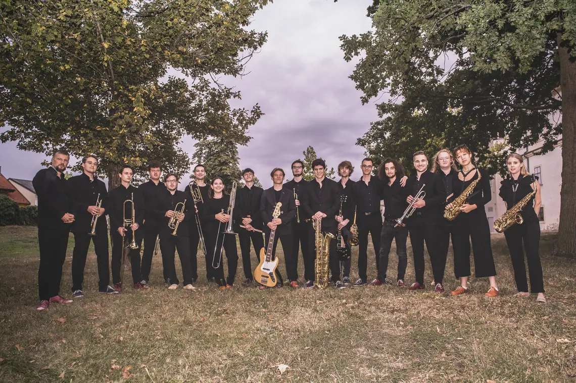 Gruppenfoto des Jugendjazzorchesters zwischen Bäumen.  