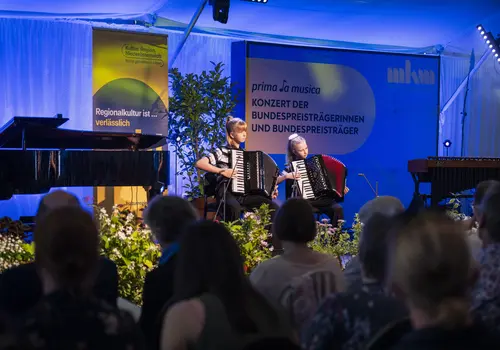 Ein Duo spielt ein Stück auf zwei Akkordeons vor.