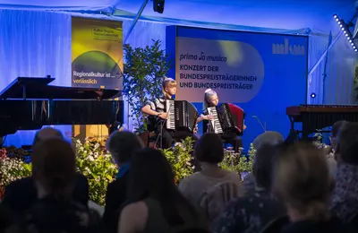 Ein Duo spielt ein Stück auf zwei Akkordeons vor.