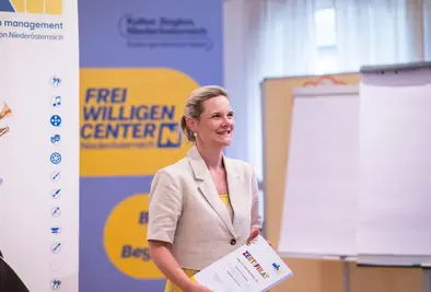 Eine Frau hält einen Stapel Zertifikate in den Händen..