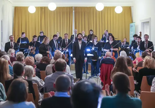 Das Orchester erhebt sich vor dem Publikum.