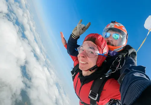 Selfie von zwei Personen, die über den Wolken im freien Fall Richtung Erde unterwegs sind.
