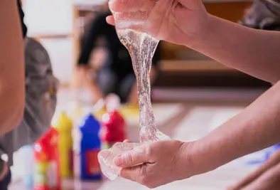 Nahaufnahme einer Person die Schleim in der Hand hält.